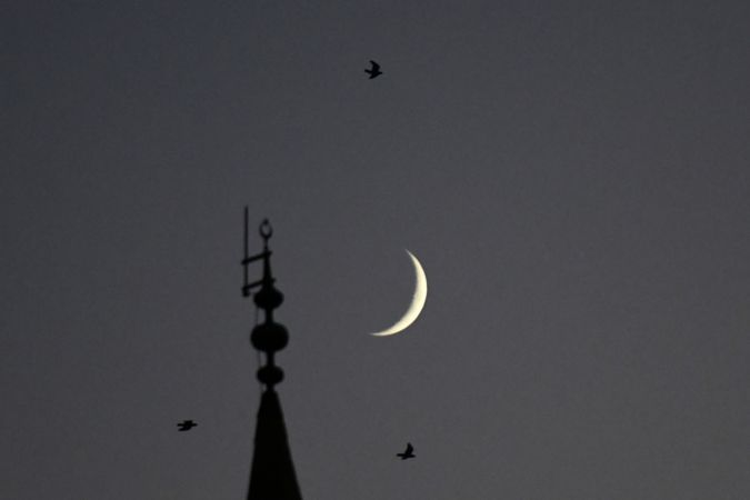 Gaziantep'te  gün batımından hemen sonra görünen hilal, cami minaresi ve kuşlarla güzel görüntü oluşturdu. 1