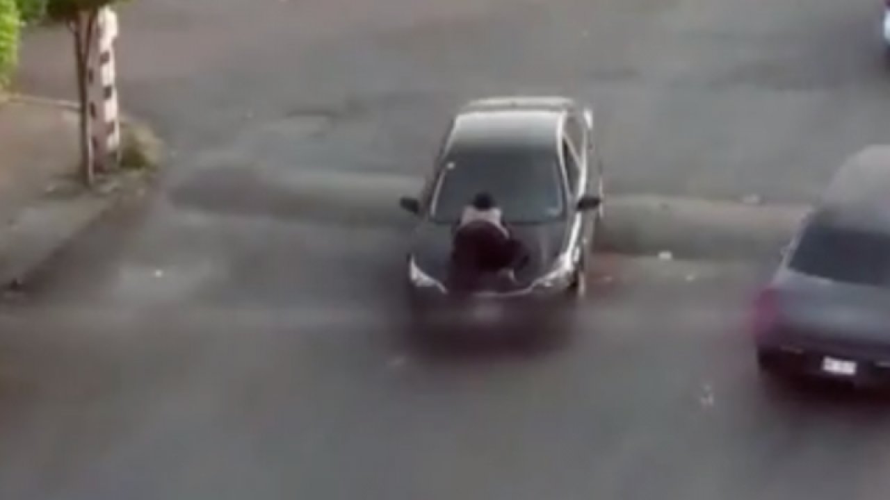 Aracının kaputundaki kadına aldırış etmeden yoluna devam etti