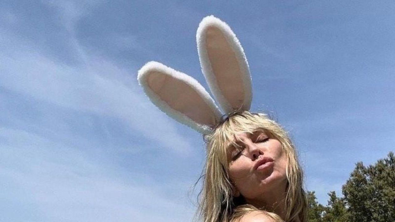 Heidi Klum sarı bikinisiyle çimlere sereserpe uzandı! Göğüs dekoltesi ile ateşli kalça pozu…